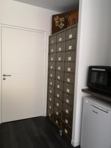 a room with a closet with drawers and a microwave at L'imprimerie, charmant pied à terre, tout confort in Rennes