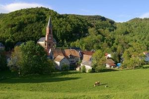 un pequeño pueblo con una iglesia en un campo en chic t3 60 m2 cosy 1 a 6 personnes rando, nature, bike park, station de ski en Le Bonhomme