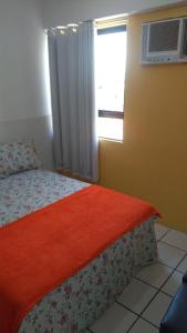 1 dormitorio con 1 cama con manta roja y ventana en Grand Beach Flat Boa viagem, en Recife