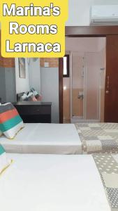 a bedroom with two beds in a room with a mirror at Marina's Rooms Xrisopolitissa Larnaca in Larnaca