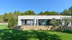 una casa con un muro in pietra e alberi di Domaine de la Galinière a Châteauneuf-le-Rouge