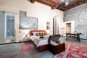 una camera con un letto e una sedia di Historical Suites - The House Of Travelers a Como