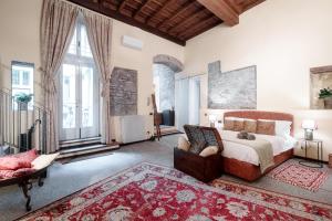 una camera con letto king-size e divano di Historical Suites - The House Of Travelers a Como