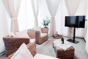 a living room with wicker chairs and a flat screen tv at Historical Suites - The House Of Travelers in Como