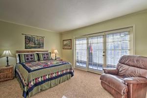um quarto com uma cama, uma cadeira e uma janela em Red River Townhome with Balcony and Mtn Views! em Red River