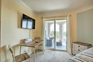 1 dormitorio con escritorio, 1 cama y puerta corredera de cristal en Inviting St Augustine Studio - Walk to the Beach!, en St. Augustine