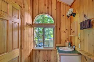 ein Badezimmer mit Waschbecken und Fenster in der Unterkunft Elk Hideaway Ashford Cottage with Hot Tub! in Ashford + 17 Fotos