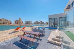 - une terrasse avec une table de pique-nique et des chaises sur la plage dans l'établissement Long Island Gouna 5BR Tawila Beach House & Pool, à Hurghada