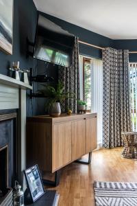 a living room with a wooden cabinet and a fireplace at Prime Ballycastle Apartment in Ballycastle