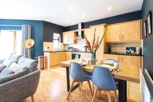 a kitchen and living room with a table and chairs at Prime Ballycastle Apartment in Ballycastle