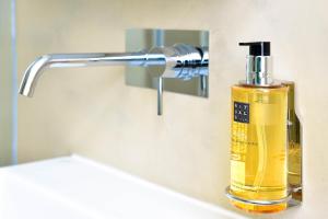 a bottle of soap sitting on a bathroom sink at My Story Hotel Augusta in Lisbon