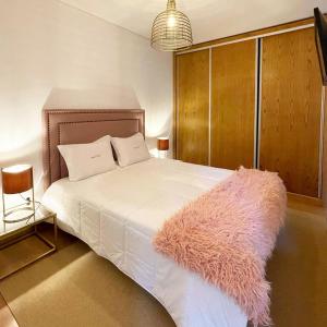 um quarto com uma cama branca e um tapete rosa em Quinta da Corga em Prova