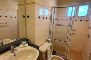 e bagno con doccia, servizi igienici e lavandino. di Gateway Suite Cozy Dream Home for Nature Lover 8A a Kuching