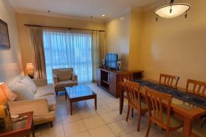 un soggiorno con divano e tavolo di Gateway Suite Cozy Dream Home for Nature Lover 8A a Kuching