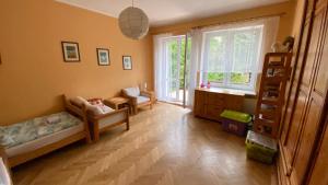 a bedroom with two beds and a desk and a window at Pokoje Gościnne Hetmanska in Gdynia