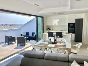 a living room with a couch and a table and a kitchen at Luxury Penthouse Jacobo - The View Fuengirola in Fuengirola