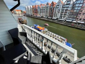 einen Balkon mit Blick auf den Fluss und die Gebäude in der Unterkunft Apartamenty MICHEL Gdańsk Centrum BOUTIQUE HOTEL in Danzig