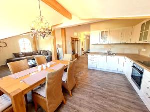 a kitchen and dining room with a wooden table and chairs at Ferienwohnung Kaiserblick in Grassau