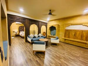 a living room with a blue couch and chairs at Hotel Grand Khalifa in Jaisalmer
