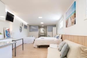 een hotelkamer met 2 bedden en een bank bij Casa El Castañal con Piscina Privada in Vigo