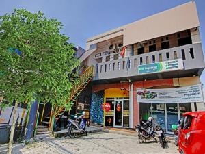 duas motos estacionadas em frente a um edifício em SUPER OYO 90358 Poris Residence Syariah em Porisgaga