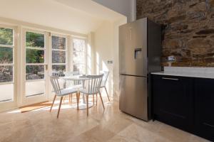 a kitchen with a table with chairs and a refrigerator at Crossgate in Durham