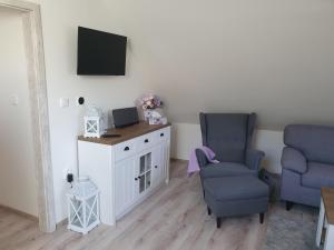 a living room with two chairs and a tv at Apartmán Bobo in Stožok