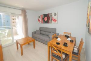 uma sala de estar com um sofá e uma mesa em Aguamarina 57b em Calpe