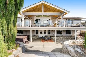 a large house with a deck and a patio at La Via Bella Retreat by the Lake in Manson