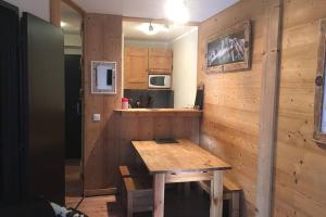 una cucina con un tavolo di legno in una stanza di Charmant appartement, centre ville, vue Mont-Blanc a Chamonix-Mont-Blanc