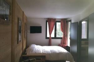 シャモニー・モンブランにあるCharmant appartement, centre ville, vue Mont-Blancのベッドルーム1室(ベッド1台、窓2つ付)