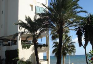 un edificio bianco con palme vicino all'oceano di Apartment Boulevard 302 a Estepona