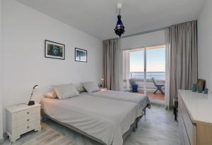 una camera da letto con un letto e vista sull'oceano di Apartment Boulevard 302 a Estepona Altre 18 foto