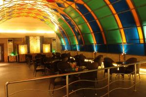 ein Restaurant mit einer farbenfrohen Decke sowie Tischen und Stühlen in der Unterkunft Ofoq Al Raha Hotel Apartment in Ta'if