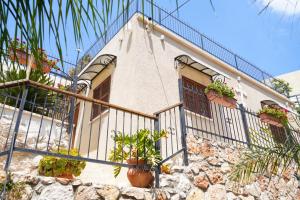 ein Haus mit Topfpflanzen und einem Zaun in der Unterkunft Abu Hanna Boutique by Ahlan Hospitality in Nazareth