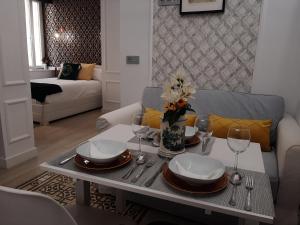 a living room with a table with plates and wine glasses at LA SUITE DEL CONDE LUXURY SUITES in Seville