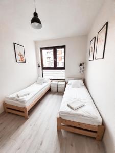 a room with two beds and a window at Apartament Kraków Arena No. 100 in Krakow