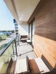 a balcony with chairs and a view of the ocean at Apartament Kraków Arena No. 100 in Kraków