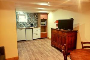 a kitchen with a tv on top of a wooden cabinet at Les berges du Doron in Planay