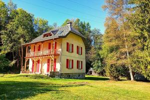a large house with red windows on a green field at Les berges du Doron in Planay