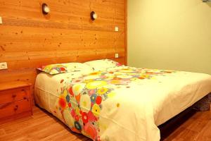 a bed in a bedroom with a wooden wall at Les berges du Doron in Planay