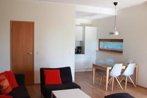 un soggiorno con divano, tavolo e sedie di Papli Apartments a Pärnu