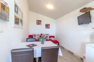 een eetkamer met een tafel en een tv bij Apartments Sveti Leonard in Oprtalj