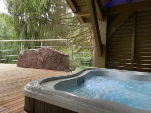 a hot tub on the deck of a house at L'ilet aux 2 étangs in Saint-Nabord