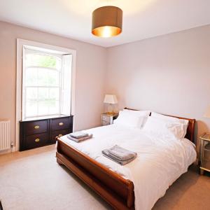 - une chambre avec un grand lit et une fenêtre dans l'établissement Rounceval House, à Chipping Sodbury