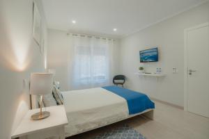 1 dormitorio blanco con 1 cama y 1 silla en 20 da Vila - Messines Valley, en São Bartolomeu de Messines