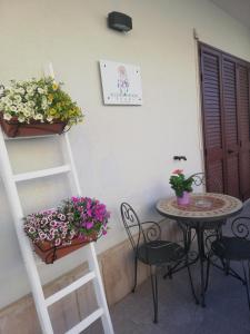 Cette chambre dispose d'une table et d'une échelle fleurie. dans l'établissement B&B Acchiappasogni, à Corigliano dʼOtranto