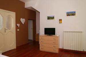 a bedroom with a television on a dresser with a door at La Casetta di Renato in Mormanno