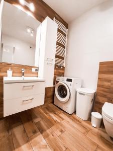 a bathroom with a washing machine and a washer at Apartament Kraków Arena in Krakow