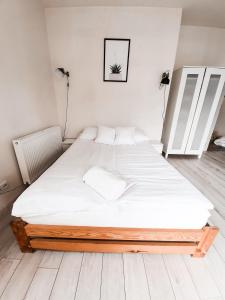 a bedroom with a large bed with white sheets at Apartament Kraków Arena in Krakow